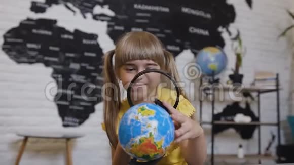 一个在放大镜里玩耍的可爱女孩的肖像女孩透过放大镜研究视频的预览图