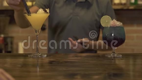 在咖啡馆的酒吧柜台用碎冰做酒精鸡尾酒酒保把吸管插在饮料里视频的预览图