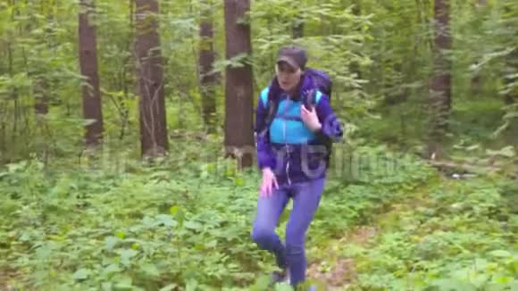 惊慌失措的女人带着背包迷失在树林里求救视频的预览图
