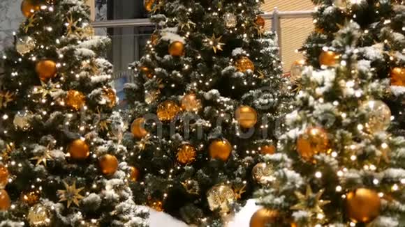 三棵装饰精美的圣诞树上面有大金银球星星花环和人造雪视频的预览图