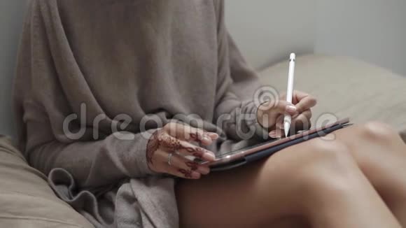 一个拿着指甲花女人的手近拍一个拿着指甲花的女人在平板上画一支铅笔视频的预览图