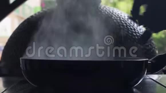 戴着黑色手套的职业女性在煎锅里用火焰烹饪视频的预览图