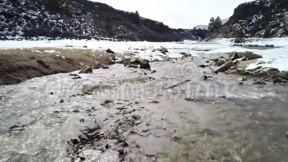 大自然中冰冷的河水穿过岩石峡谷两岸积雪视频的预览图