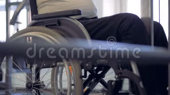 一个残疾人坐在轮椅上用金属棒做运动视频的预览图