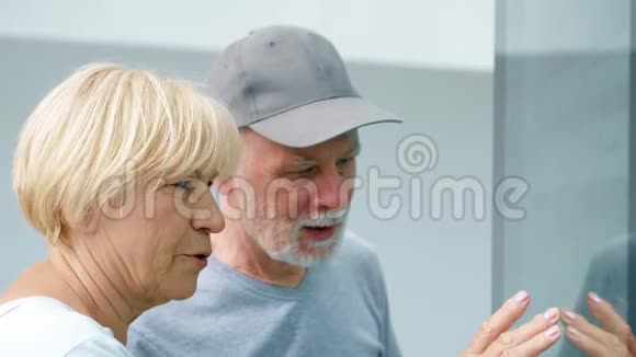 年长夫妇使用触摸屏女性通过触摸屏幕做手势寻找信息视频的预览图