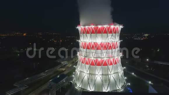 在明亮的投影灯光下围绕冷却塔的空中运动视频的预览图