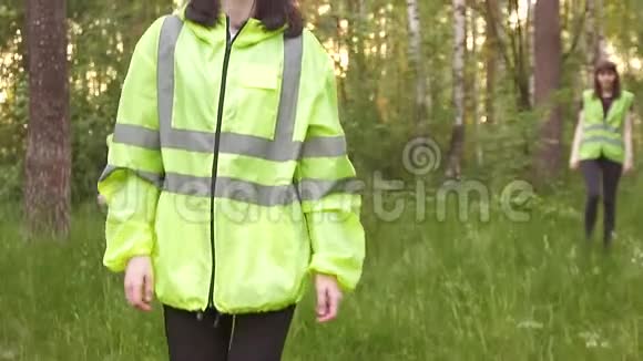 女志愿者穿着绿色背心在树林里搜寻失踪的人大声叫着视频的预览图