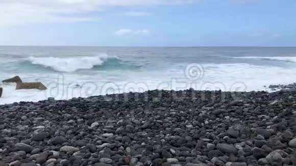 大卵石海滩和海浪到达海岸的时间间隔特内里费岛岩石海岸视频的预览图