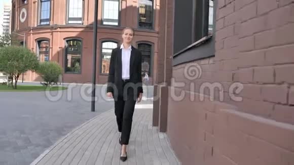 微笑的女商人在办公楼附近散步视频的预览图
