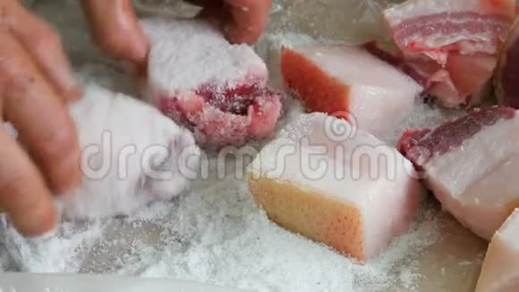 男性屠夫用盐把大块猪肉包在脂肪和皮肤上视频的预览图