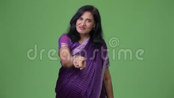 成熟快乐美丽的印度女人一边看镜头一边穿着莎莉的传统服装视频的预览图