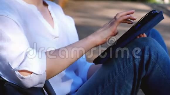 在公园里用平板电脑工作的女人关门视频的预览图