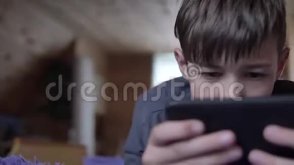 男孩撒谎用电话和朋友聊天玩游戏玩得开心视频的预览图