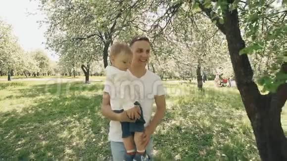 父子在公园散步儿子在父亲手视频的预览图
