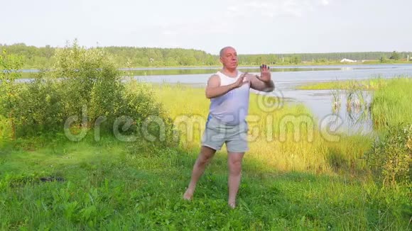 一位中年男子早上在湖边做瑜伽呼吸视频的预览图