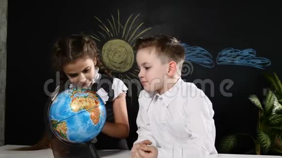 学校观念小学生们坐在书桌前玩地球仪孩子们选择度假旅游的地方视频的预览图