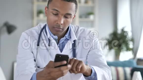 放松非裔美国人医生在智能手机上的打字信息视频的预览图