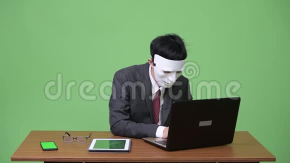 戴着面具一起使用电子设备的黑客商人视频的预览图