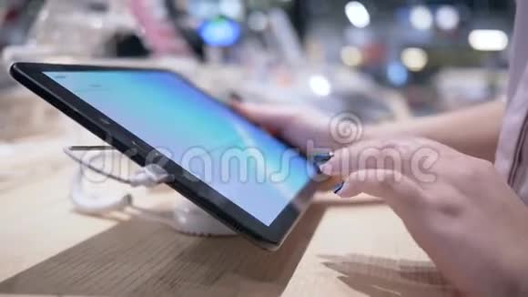 买家手使用现代平板电脑与触摸屏电子商店模糊的背景特写视频的预览图