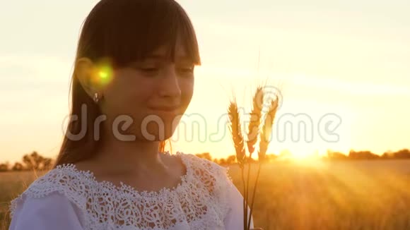 小女孩手里拿着小麦在夕阳的照耀下微笑视频的预览图
