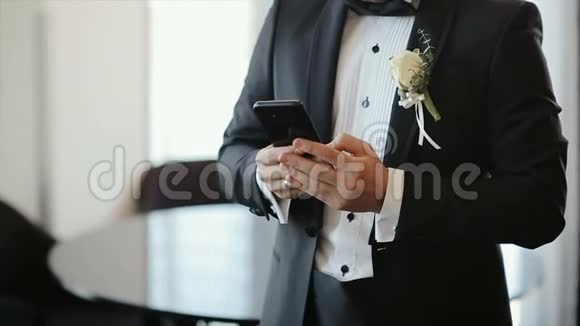穿西装的人用他的手机社交网络新郎给新娘打字按摩博客智能手机视频的预览图