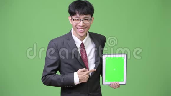 年轻快乐的亚洲商人用数码平板电脑对着镜头手指指指点点视频的预览图