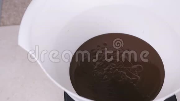 把液体黑巧克力倒在白色的碗里特写镜头视频的预览图