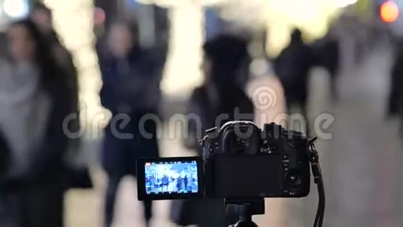 照相机站在街上的三脚架上她用自动快照创建一个延时视频视频的预览图