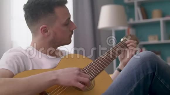 手持镜头的人在他舒适的客厅里弹吉他视频的预览图
