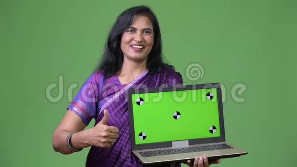 成熟快乐美丽的印度女人手提电脑竖起大拇指视频的预览图