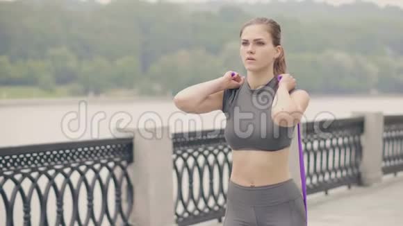 健身妇女训练蹲式运动与运动拓展运动户外锻炼视频的预览图