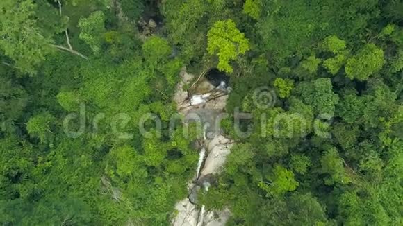 鸟瞰热带河流在野生雨林的石崖上流动无人机可以看到岩石河和视频的预览图