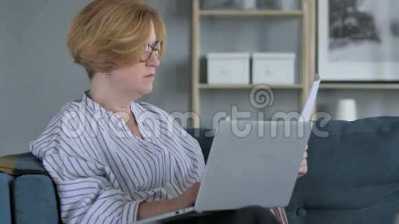 Penve老年妇女做纸工和使用笔记本电脑视频的预览图