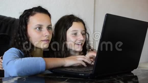 快乐的姐妹们用笔记本电脑视频的预览图