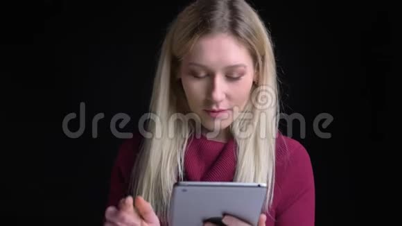年轻迷人的白种人金发女性使用平板电脑和显示绿色屏幕的特写镜头视频的预览图
