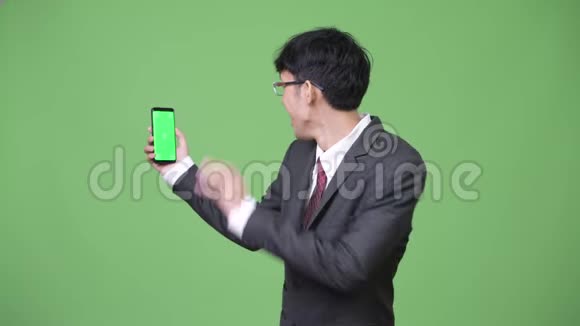 年轻的亚洲商人视频通话和显示电话摄像头视频的预览图