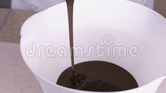 把液体黑巧克力倒在白色的碗里特写镜头视频的预览图