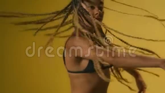 黑色的女人在黄色的背景上跳舞非洲女子舞蹈肖像视频的预览图