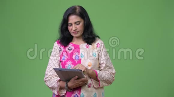 成熟快乐美丽的印度女人使用数字平板电脑得到好消息视频的预览图