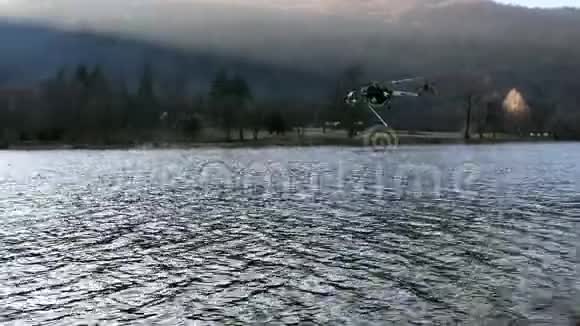 消防直升机埃里克森在意大利瓦尔甘纳的吉尔拉湖上方的山火中取水视频的预览图