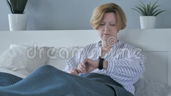 坐在床上等待老年妇女看时间视频的预览图