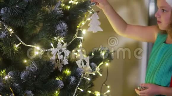 穿着绿色连衣裙和圣诞帽的快乐女孩少年女学生装扮成一棵大圣诞树圣诞节传统视频的预览图