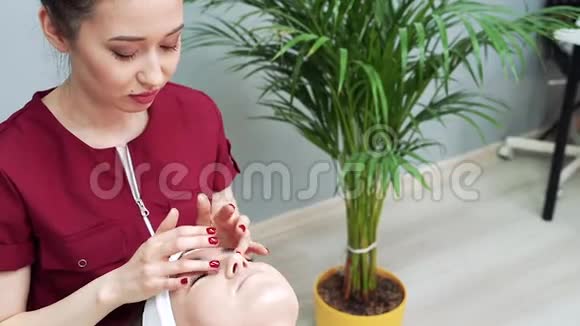 美容诊所年轻女性做专业的面部手术美容师在女性脸上做按摩视频的预览图
