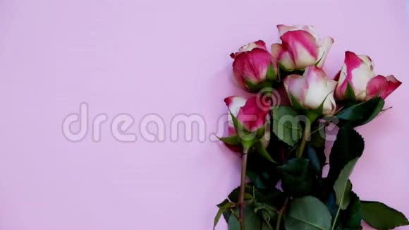 带爱的贺卡礼品和粉色木板上的鲜花可俯瞰全景视频的预览图