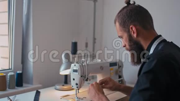 裁缝师正在准备缝纫马辛与螺纹工作在时装工作室视频的预览图