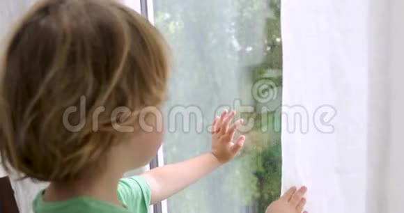 男孩站着看着窗外视频的预览图