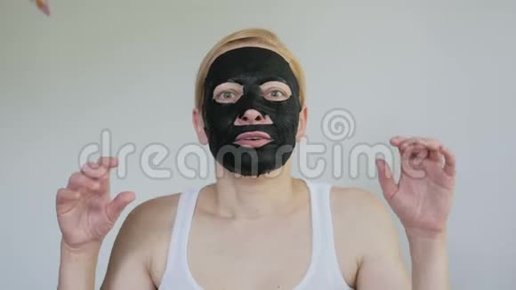 一个戴着黑色化妆面具的女人挥舞着手臂想吓唬她视频的预览图