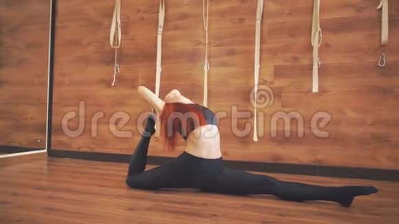 年轻女孩坐在地板上做伸展运动视频的预览图
