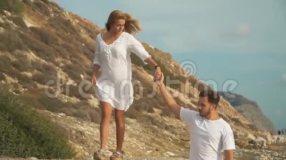 美丽的年轻夫妇牵着手走向日落在海滩上互相交谈玩得很开心慢慢视频的预览图