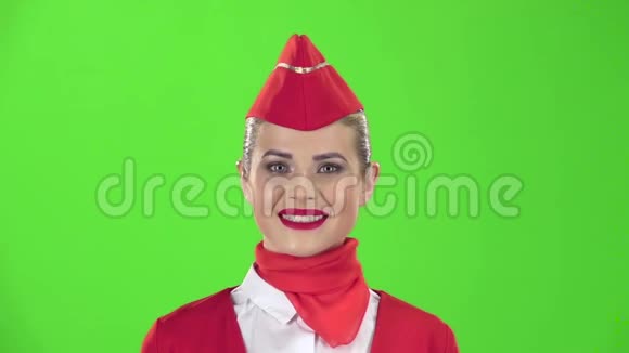 穿着红色西装的女乘务员眨了眨眼睛轻轻地调情发出一个吻绿色屏幕慢动作关门视频的预览图